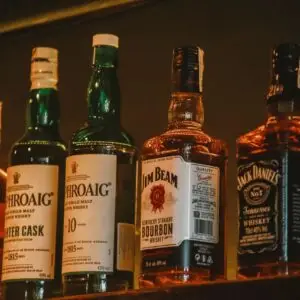 A selection of premium whiskey brands elegantly arranged on a dimly lit display shelf.